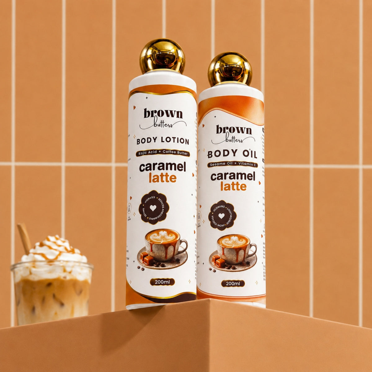 Brown Butters Caramel Latte Dessert Glow Duo: two 200ml gold-capped bottles on a shelf with a coffee prop.