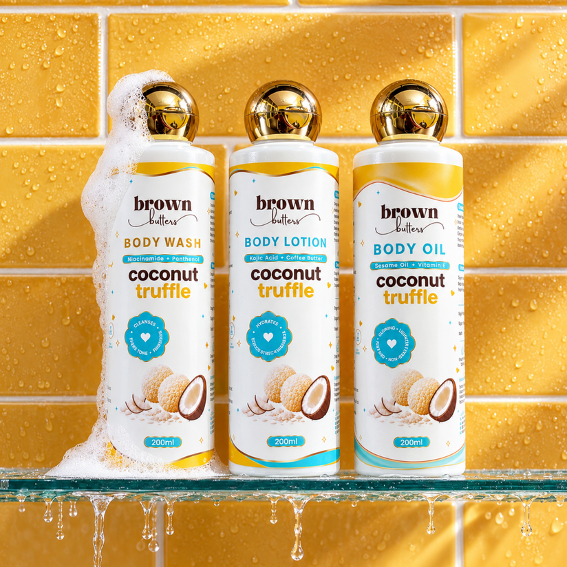 Brown Butters Coconut Truffle Body Wash, Lotion and Oil bottles on a wet gold tiled shelf