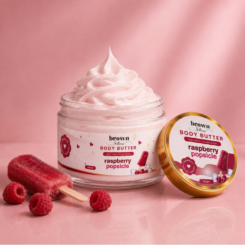 Brown Butters Raspberry Popsicle Body Butter jar of pink whipped cream with gold lid, popsicle and raspberries