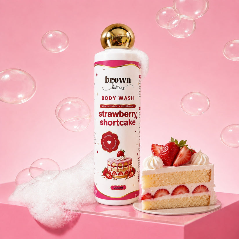 Brown Butters Strawberry Shortcake Body Wash bottle on a pink platform with a cake slice and floating bubbles