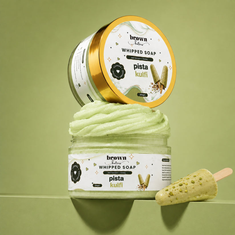 Brown Butters Pista Kulfi Whipped Soap in a clear jar with gold lid and a soap popsicle prop on light green