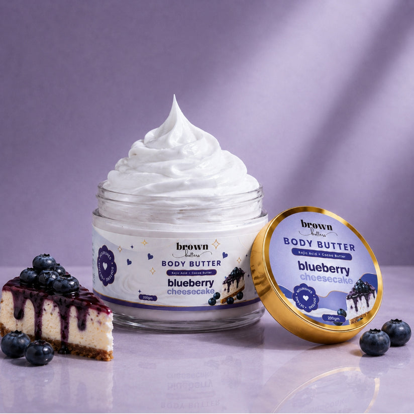 Brown Butters Blueberry Cheesecake Body Butter jar of lavender cream with gold lid, cheesecake slice and blueberries