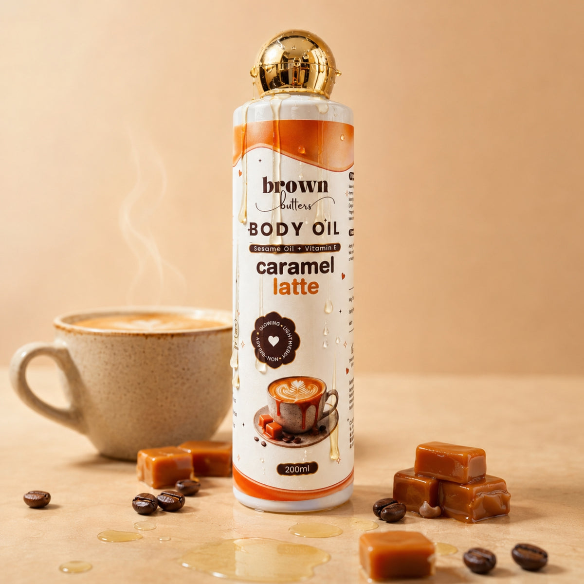 Brown Butters Caramel Latte Body Oil 200ml bottle on beige with caramel cubes, coffee beans and a steaming cup