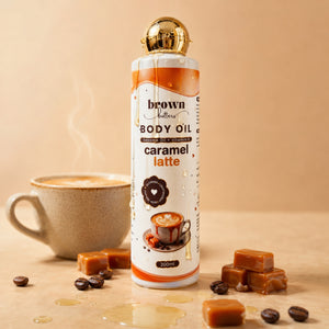 Brown Butters Caramel Latte Body Oil 200ml bottle on beige with caramel cubes, coffee beans and a steaming cup
