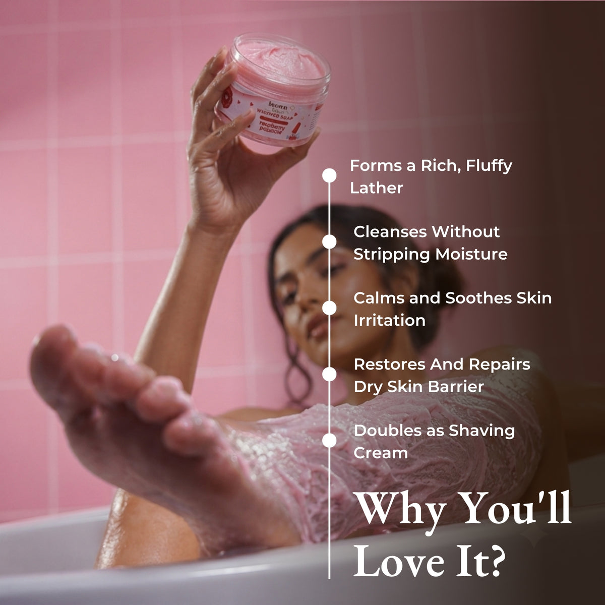 Brown Butters Raspberry Popsicle Whipped Soap held in a bathtub with a benefits list including rich, fluffy lather