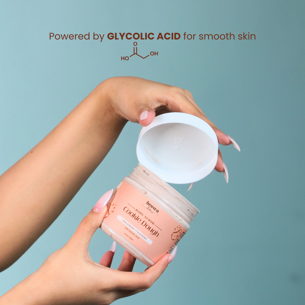 Brown Butters Cookie Dough Body Scrub glycolic acid callout with hands opening the peach jar