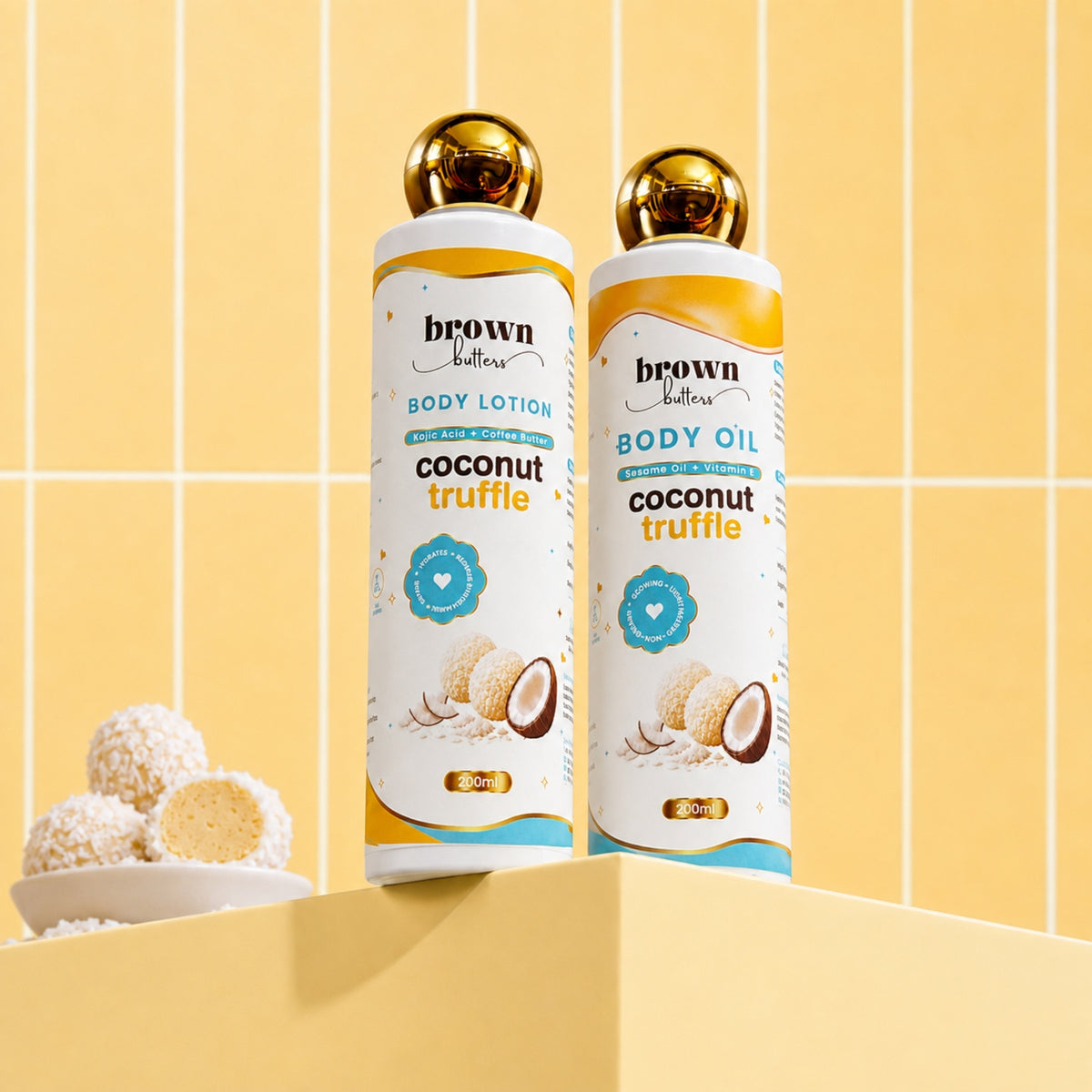 Brown Butters Coconut Truffle Dessert Glow Duo lotion and oil bottles with gold caps on a yellow tiled set.